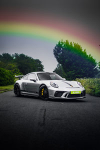 Porsche GT3 captured underneath a colourful Rainbow
